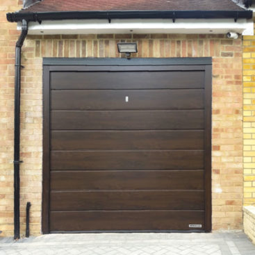 A Hormann LPU42 M Ribbed, Insulated Sectional Garage Door finished in a Dark Oak Decograin