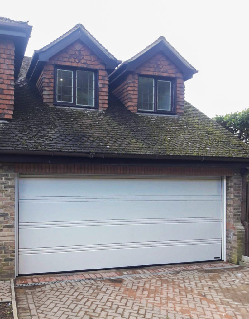 A Hormann LPU42 T-Ribbed Automated Sectional Garage Door finished in Light Grey