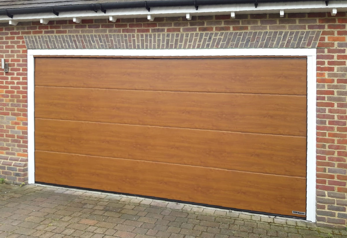 M Ribbed Hormann Sectional Garage Door In Night Oak Insulated And Remote Control For That Touch Of Luxury And Style Sectional Garage Doors Doors Garage Doors