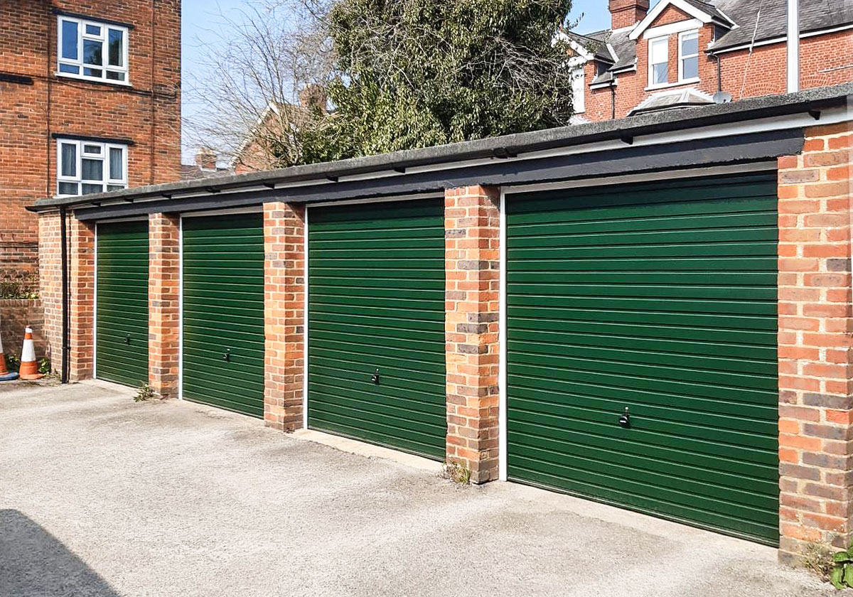 A row of four Garador Horizon Steel Retractable Up & Over Garage Doors in Moss Green