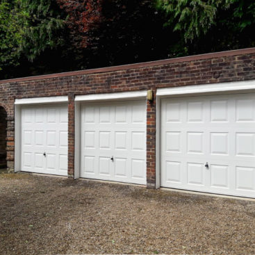 A trio of Garador Georgian up and over garage doors in white