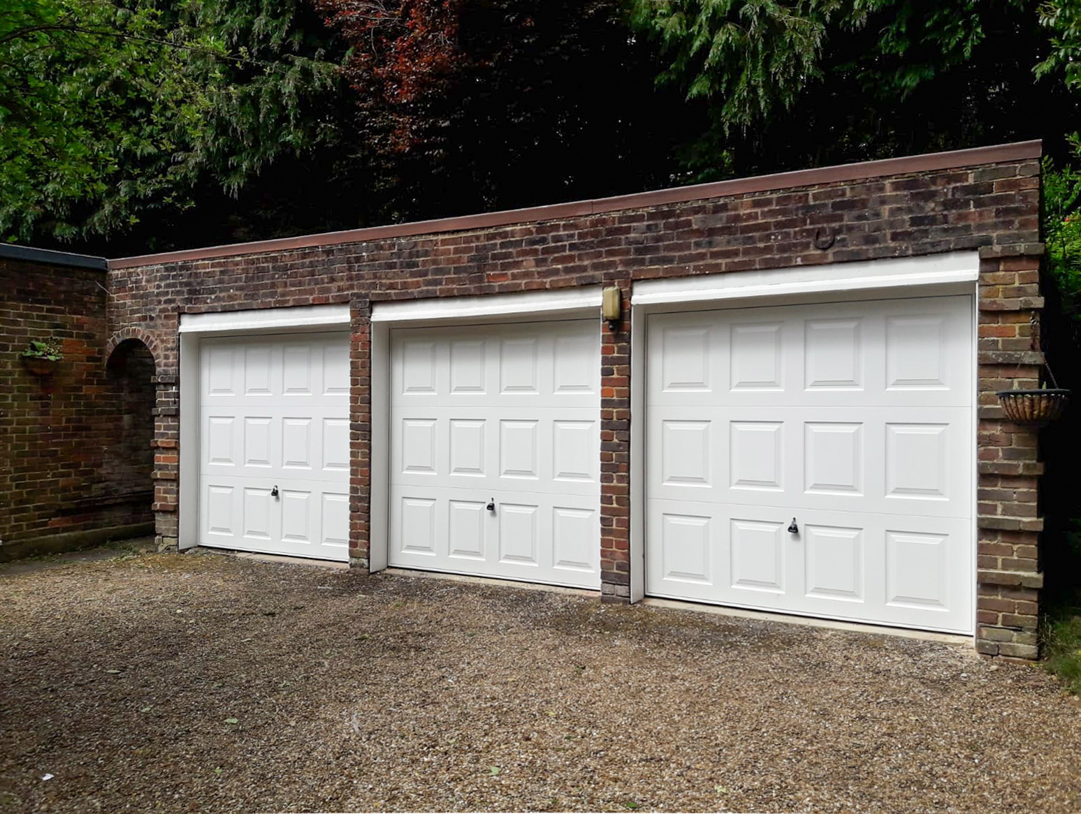 A trio of Garador Georgian up and over garage doors in white